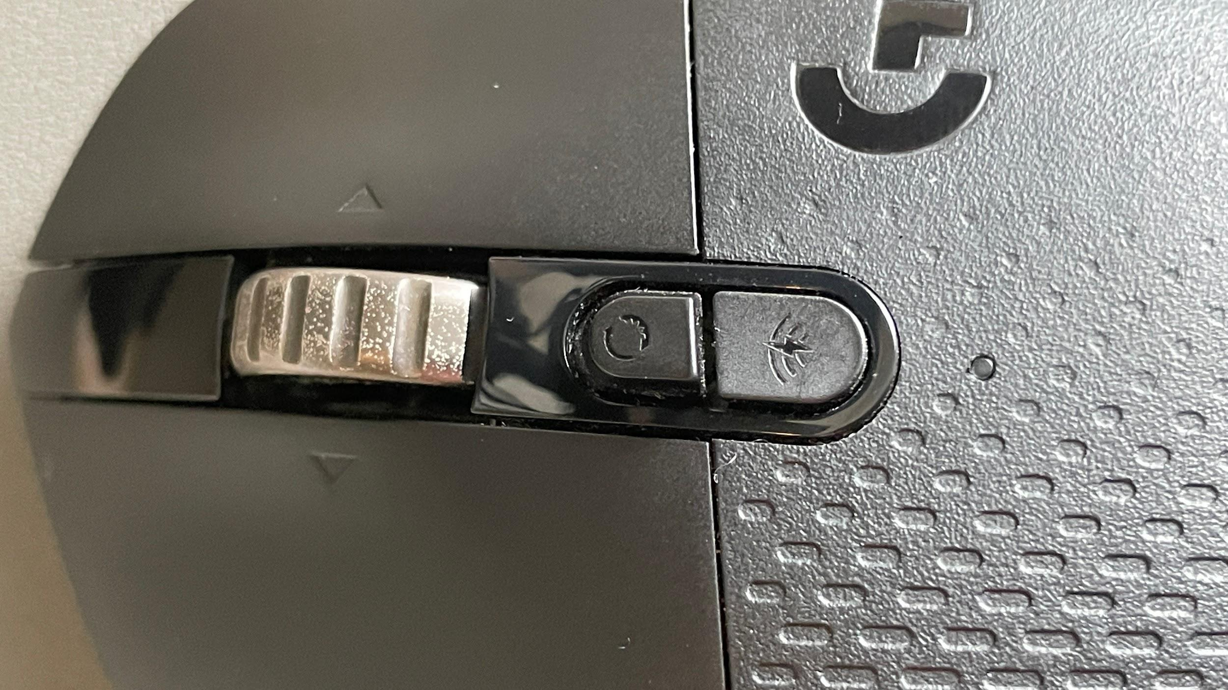 Close-up of the G604 infinite scroll wheel and wireless connectivity toggle